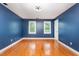 Bedroom with blue walls, hardwood floors and natural light at 105 Houston Cir, Cary, NC 27513