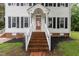Welcoming front entrance with brick stairs and a red front door with white railings at 105 Houston Cir, Cary, NC 27513
