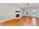 Living room with a painted brick fireplace, hardwood floors, and natural light at 105 Houston Cir, Cary, NC 27513