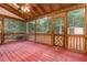 Cozy screened porch with wood ceiling, red flooring, and backyard views at 105 Houston Cir, Cary, NC 27513