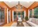 Bright sunroom featuring wood paneling, chandelier, and large windows offering outdoor views at 105 Houston Cir, Cary, NC 27513