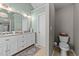 Well-lit bathroom features a double vanity with granite countertop and a patterned rug on the tiled floor at 105 Stoney Dr, Durham, NC 27703