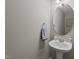 Powder room with a pedestal sink, round mirror, and a patterned hand towel at 105 Stoney Dr, Durham, NC 27703