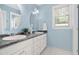 Bright bathroom with double sinks, granite countertop, white cabinets, and round mirrors at 10516 Cokesbury Ln, Raleigh, NC 27614