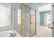 Bathroom with a shower enclosure with gold trim, a bathtub, and a window with bright light at 10516 Cokesbury Ln, Raleigh, NC 27614