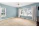 Carpeted bedroom featuring a ceiling fan, two windows and a painted blue accent wall at 10516 Cokesbury Ln, Raleigh, NC 27614