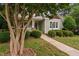 Beautiful home exterior with a well-manicured lawn and mature tree shading the facade at 10516 Cokesbury Ln, Raleigh, NC 27614