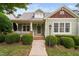Charming green home featuring a cozy front porch and professionally landscaped front yard at 10516 Cokesbury Ln, Raleigh, NC 27614