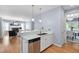 Stylish kitchen featuring stainless steel appliances, white cabinets and a view into the living room and dining room at 10516 Cokesbury Ln, Raleigh, NC 27614