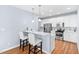 Kitchen with breakfast bar, stainless steel appliances, white cabinets and stylish pendant lighting at 10516 Cokesbury Ln, Raleigh, NC 27614