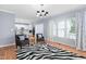 Bright living room featuring a zebra-striped rug, modern lighting and two armchairs with views to the kitchen at 10516 Cokesbury Ln, Raleigh, NC 27614