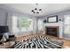 Spacious living room with a fireplace, large windows, and hardwood floors at 10516 Cokesbury Ln, Raleigh, NC 27614
