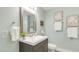 Cozy bathroom showcasing a dark vanity, white sink and a framed mirror at 106 E Delafield Ave, Durham, NC 27704