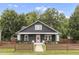 Charming home featuring a dark exterior with a pink front door and manicured front lawn at 106 E Delafield Ave, Durham, NC 27704