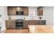 The spacious kitchen features stainless appliances, granite counters, a tile backsplash, and sleek cabinetry at 106 E Delafield Ave, Durham, NC 27704