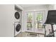 Functional laundry area with a stacked washer and dryer, near French doors to backyard at 106 E Delafield Ave, Durham, NC 27704