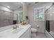 Bright bathroom with a white vanity, large mirror, and shower featuring light tile and glass doors at 107 Ashwick Ct, Cary, NC 27513