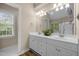 Bathroom featuring double vanity, great lighting, and large mirror at 107 Ashwick Ct, Cary, NC 27513