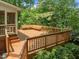 Expansive wooden deck features built-in seating and is surrounded by mature trees and landscaping at 107 Ashwick Ct, Cary, NC 27513