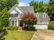 Beautiful two-story home with a well-manicured lawn, mature trees, and attached garage at 107 Ashwick Ct, Cary, NC 27513
