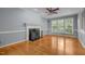 Spacious living room featuring a classic fireplace, hardwood floors, and large windows providing plenty of natural light at 107 Ashwick Ct, Cary, NC 27513