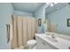 Traditional bathroom with a shower and tub, a vanity, and soft blue paint at 107 Stargrass Ave, Clayton, NC 27527