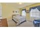 Comfortable bedroom featuring neutral carpeting, a quilt-covered bed, and soft natural light at 107 Stargrass Ave, Clayton, NC 27527