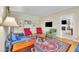 Cozy living room with hardwood floors, colorful rug, and an adjacent room featuring a fireplace at 107 Stargrass Ave, Clayton, NC 27527