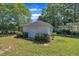 Storage shed with a single garage door surrounded by manicured landscaping under a bright blue sky at 107 Stargrass Ave, Clayton, NC 27527