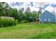 Expansive backyard featuring a lush lawn and a charming blue home at 108 Wilson Farm Ln, Clayton, NC 27527