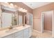 Bathroom with dual sink vanity, decorative mirror, hexagon tile flooring, and a step-in shower at 108 Wilson Farm Ln, Clayton, NC 27527