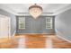 Spacious bedroom with hardwood floors, two windows, a tray ceiling, and chandelier at 108 Wilson Farm Ln, Clayton, NC 27527