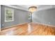 Bedroom featuring hardwood flooring, a chandelier, and natural light from two windows at 108 Wilson Farm Ln, Clayton, NC 27527