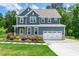 Charming two-story home boasts a manicured lawn and a classic blue exterior at 108 Wilson Farm Ln, Clayton, NC 27527