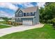 Stylish blue home features a large driveway and well-maintained landscaping at 108 Wilson Farm Ln, Clayton, NC 27527