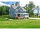 Beautifully landscaped property with a blue home, green lawn and trees at 108 Wilson Farm Ln, Clayton, NC 27527