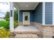 Covered front porch with a yellow door and brick accents at 108 Wilson Farm Ln, Clayton, NC 27527