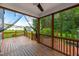 This screened porch has wood flooring and railings offering serene views of the property's landscape at 108 Wilson Farm Ln, Clayton, NC 27527