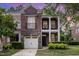 Charming brick townhouse showcasing a two-story facade, stone accents, and a quaint balcony at 109 Longchamp Ln, Cary, NC 27519