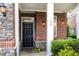 Welcoming front entrance with a black door, stone accents, and manicured landscaping at 109 Longchamp Ln, Cary, NC 27519