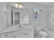 A well-lit white bathroom with a vanity, toilet, and tub/shower combination at 11012 Southwalk Ln, Raleigh, NC 27614