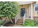 Charming front porch with brick steps, white railing, dark blue front door, and landscaping at 11012 Southwalk Ln, Raleigh, NC 27614