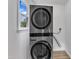 Modern laundry area with stacked washer and dryer and a bright window at 11012 Southwalk Ln, Raleigh, NC 27614
