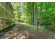 Lush backyard with mature trees and partial view of the home's exterior, ideal for outdoor activities and enjoying nature at 1104 Berwyn Way, Raleigh, NC 27615
