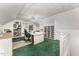Bonus room featuring craft space, green carpet, custom shelving, and a ceiling fan at 1104 Berwyn Way, Raleigh, NC 27615
