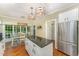Bright kitchen features a central island with granite counters and stainless-steel appliances at 1104 Berwyn Way, Raleigh, NC 27615