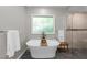 Bright bathroom showcasing a modern soaking tub next to a walk-in shower and frosted window at 1115 Trailwood Dr, Raleigh, NC 27606