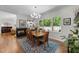 Bright dining area with wood floors, a modern chandelier, and a fireplace overlooking the outdoor scenery at 1115 Trailwood Dr, Raleigh, NC 27606