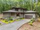 Modern home boasts meticulous landscaping and a gravel drive surrounded by a beautiful wooded area at 1115 Trailwood Dr, Raleigh, NC 27606