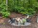 Cozy fire pit area with Adirondack chairs in a wooded backyard setting at 1115 Trailwood Dr, Raleigh, NC 27606